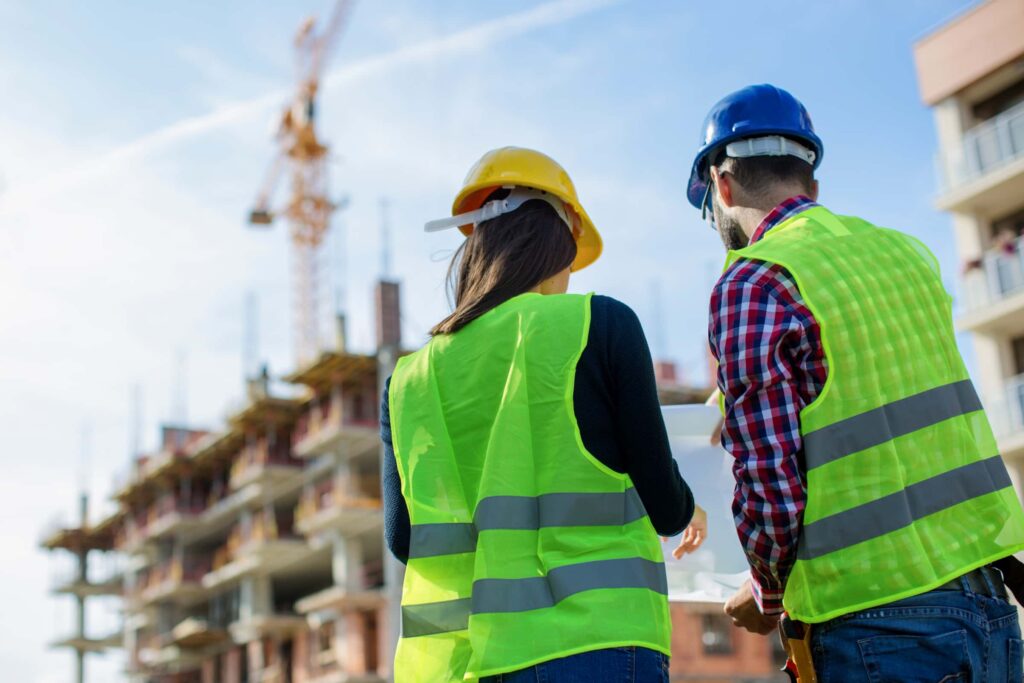 viewing a job site with safety hats and vests on