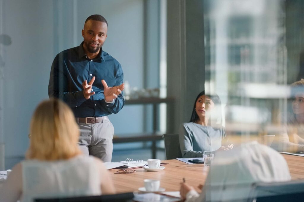man standing in the conference room to speak